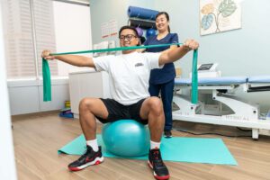 Rehabilitation techniques at the franklin chiropractic dubai, a male on hisphysical therapy wit a female physiotherapist, exercises on pillates ball